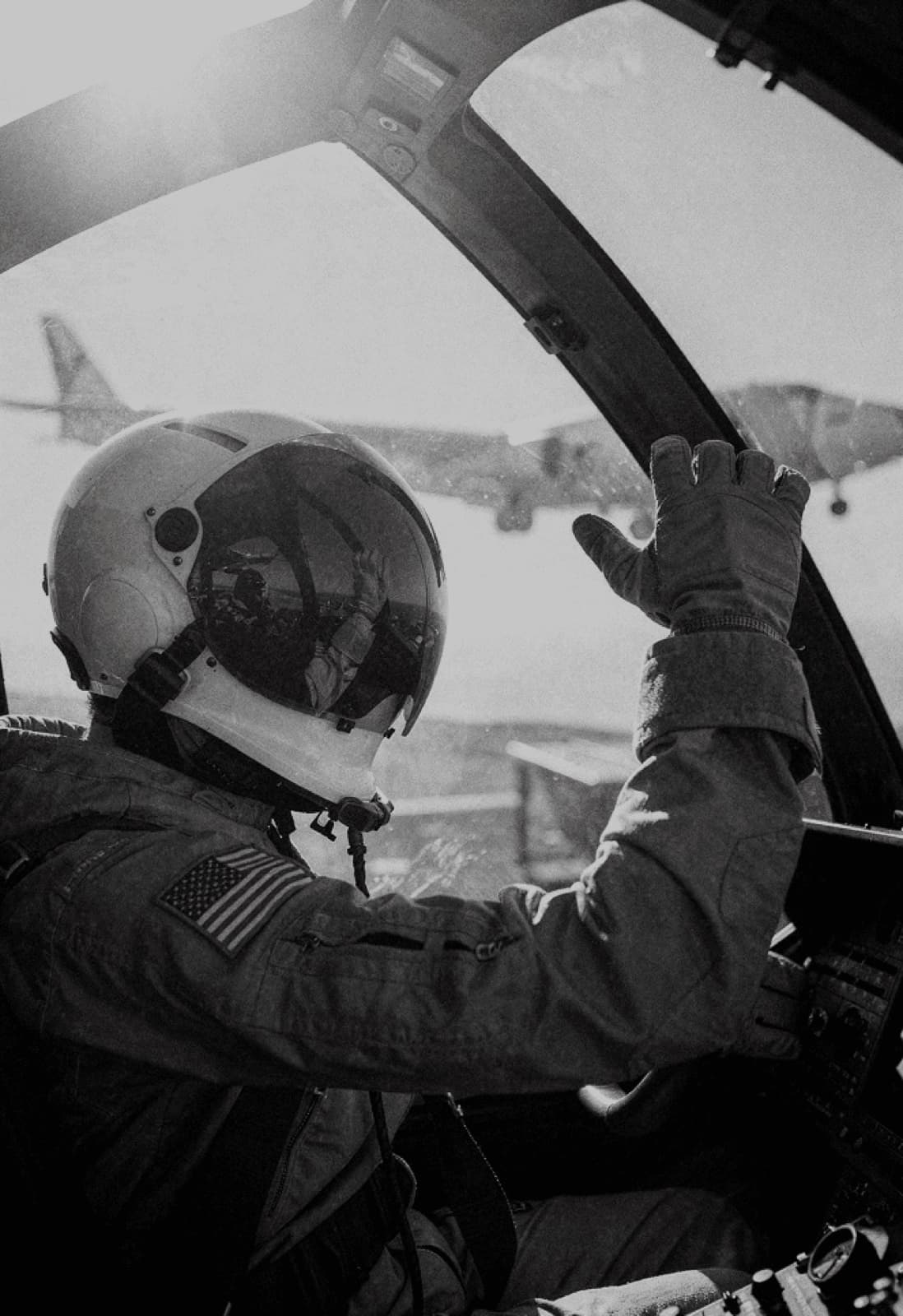 Pilot saluting a wingman from the cockpit